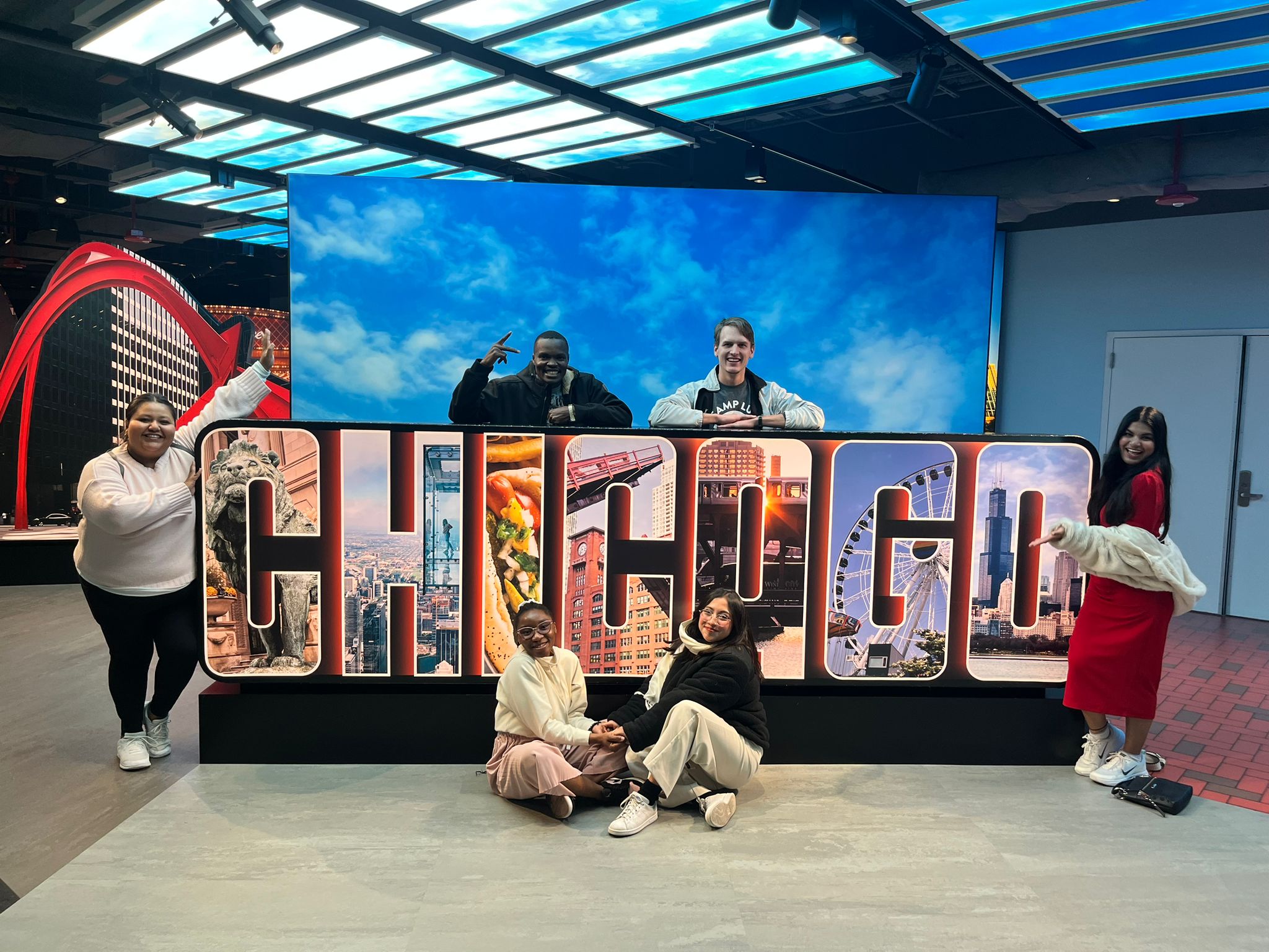 Group of young people standing around a Chicago sign