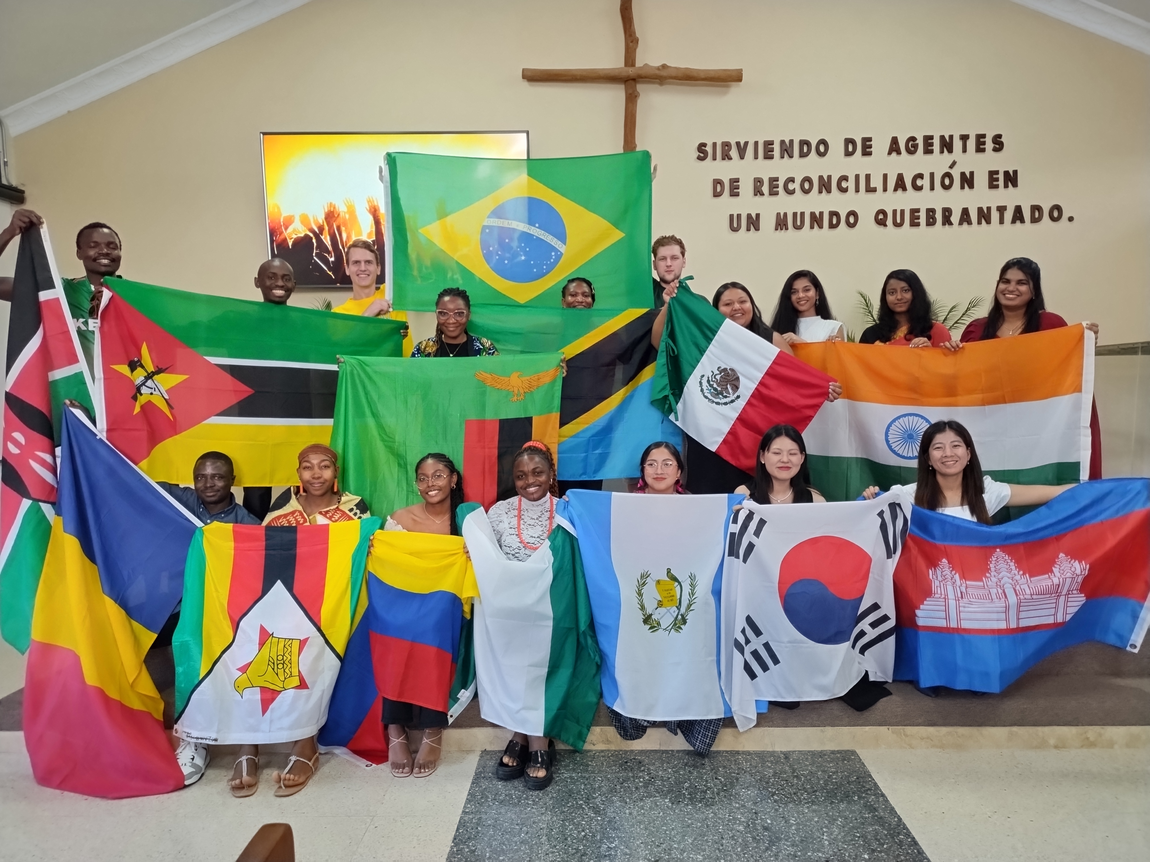Group photo of young adults holding different country flags.