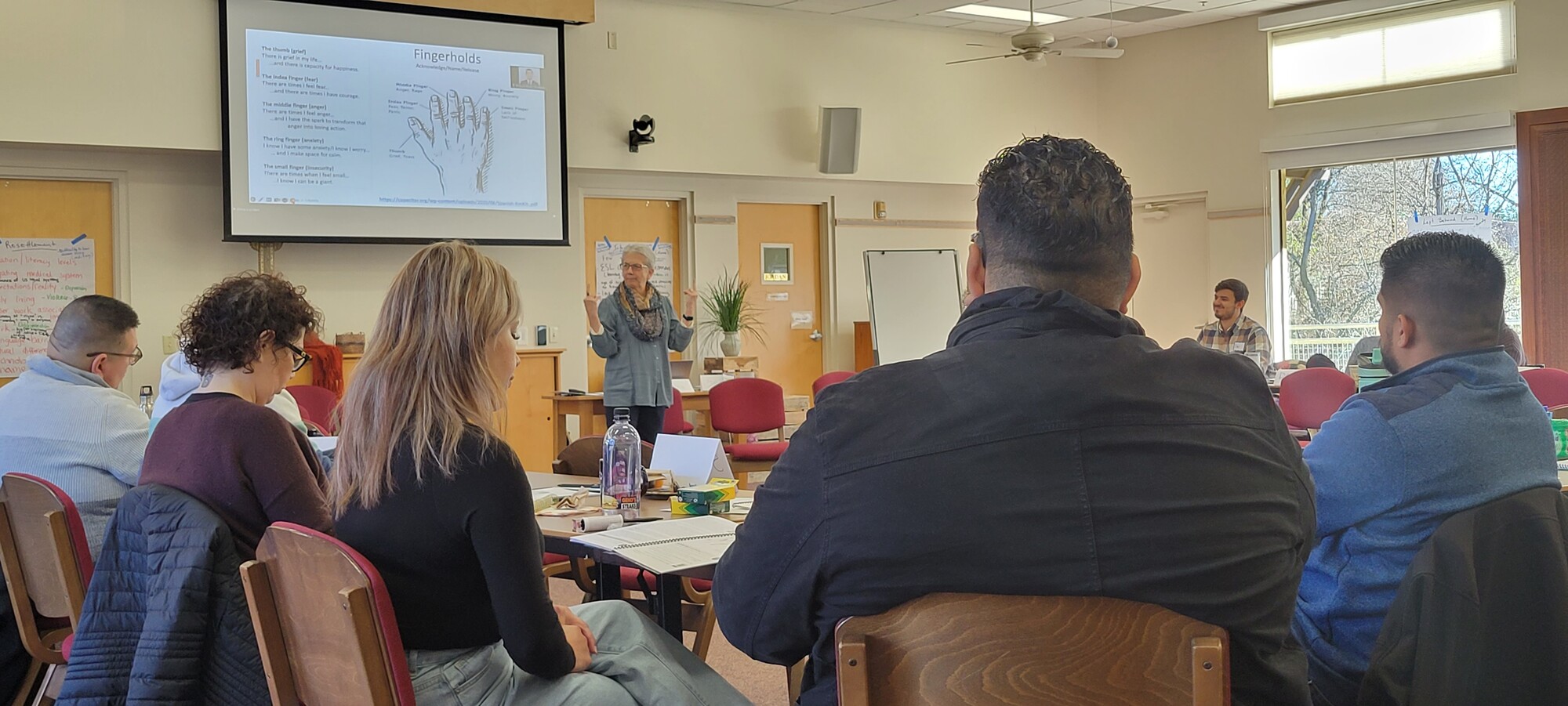 A woman speaking to a group of people seated in a conference room