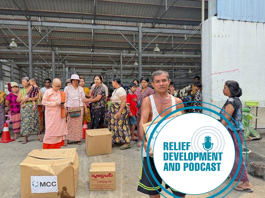 Man holding a box that says MCC, logo of relief, development and podcast