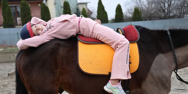 a smiling girl riding a horse