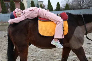 a smiling girl riding a horse
