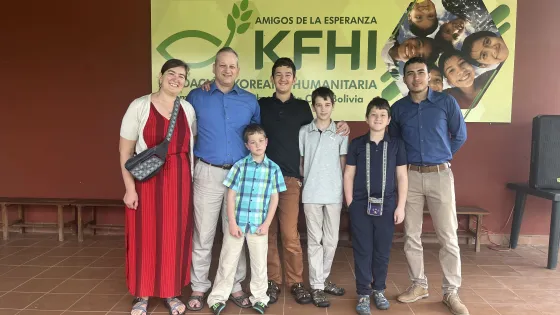 group of adults and children standing and smiling at camera