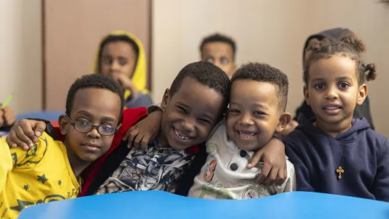 Group of boys sitting together with smiles.